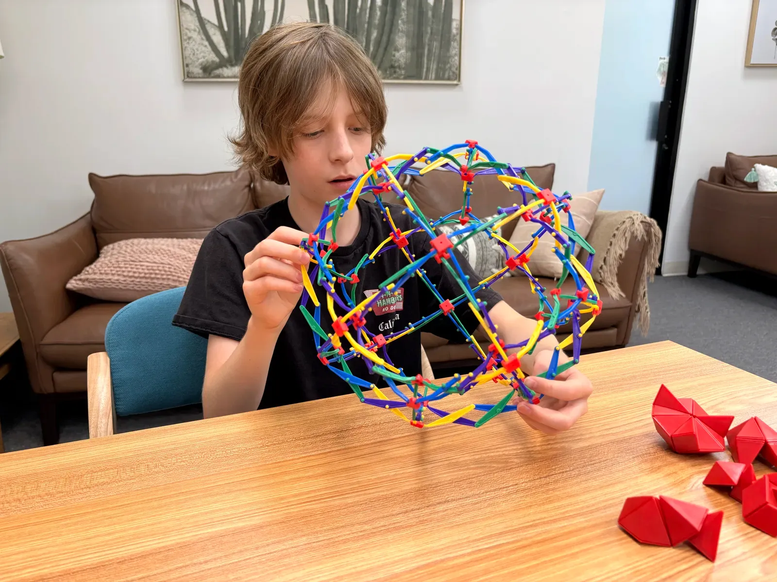 A young student playing with an expanding sphere toy during testing