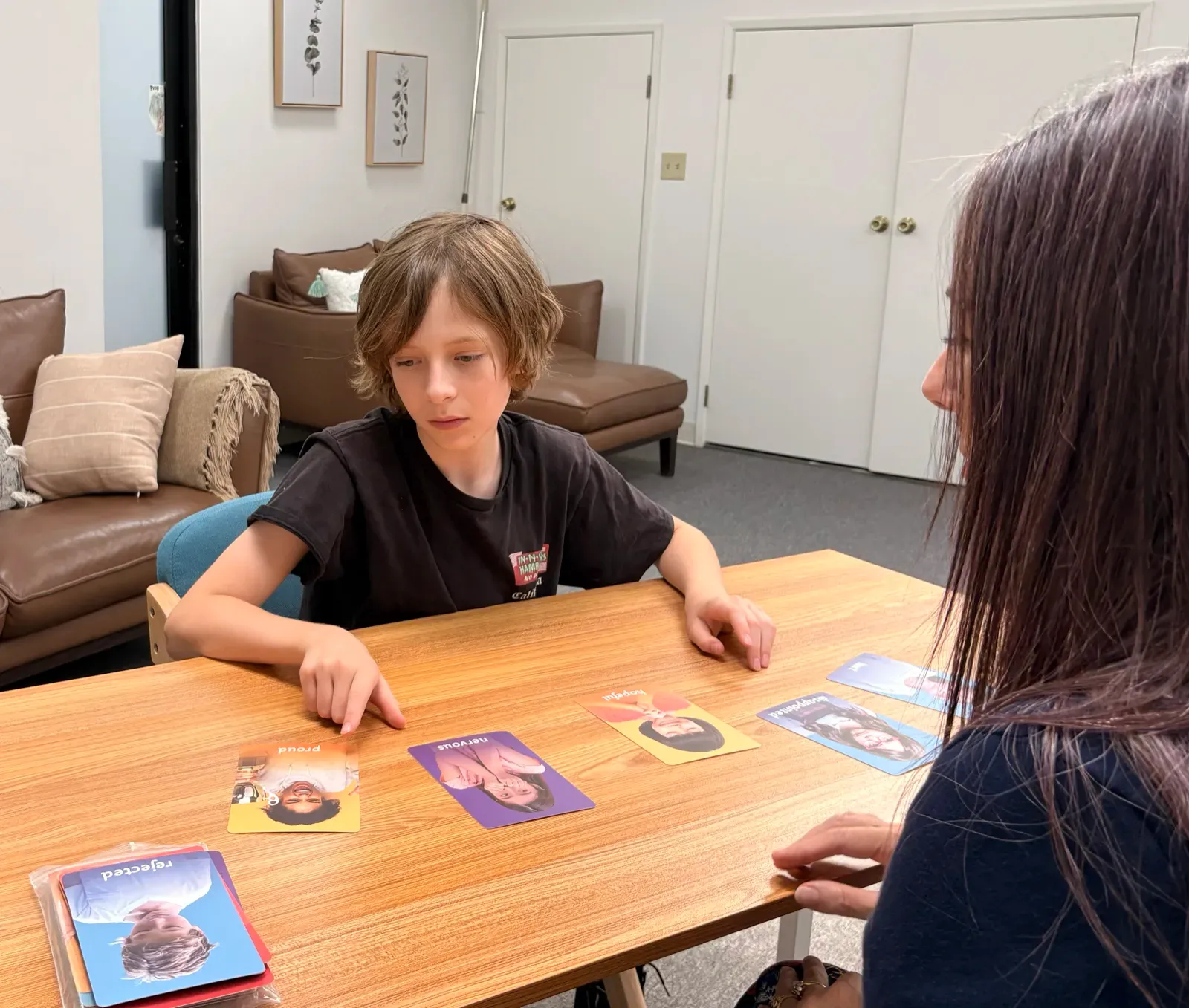 A young student sorting emotion cards during an assessment session