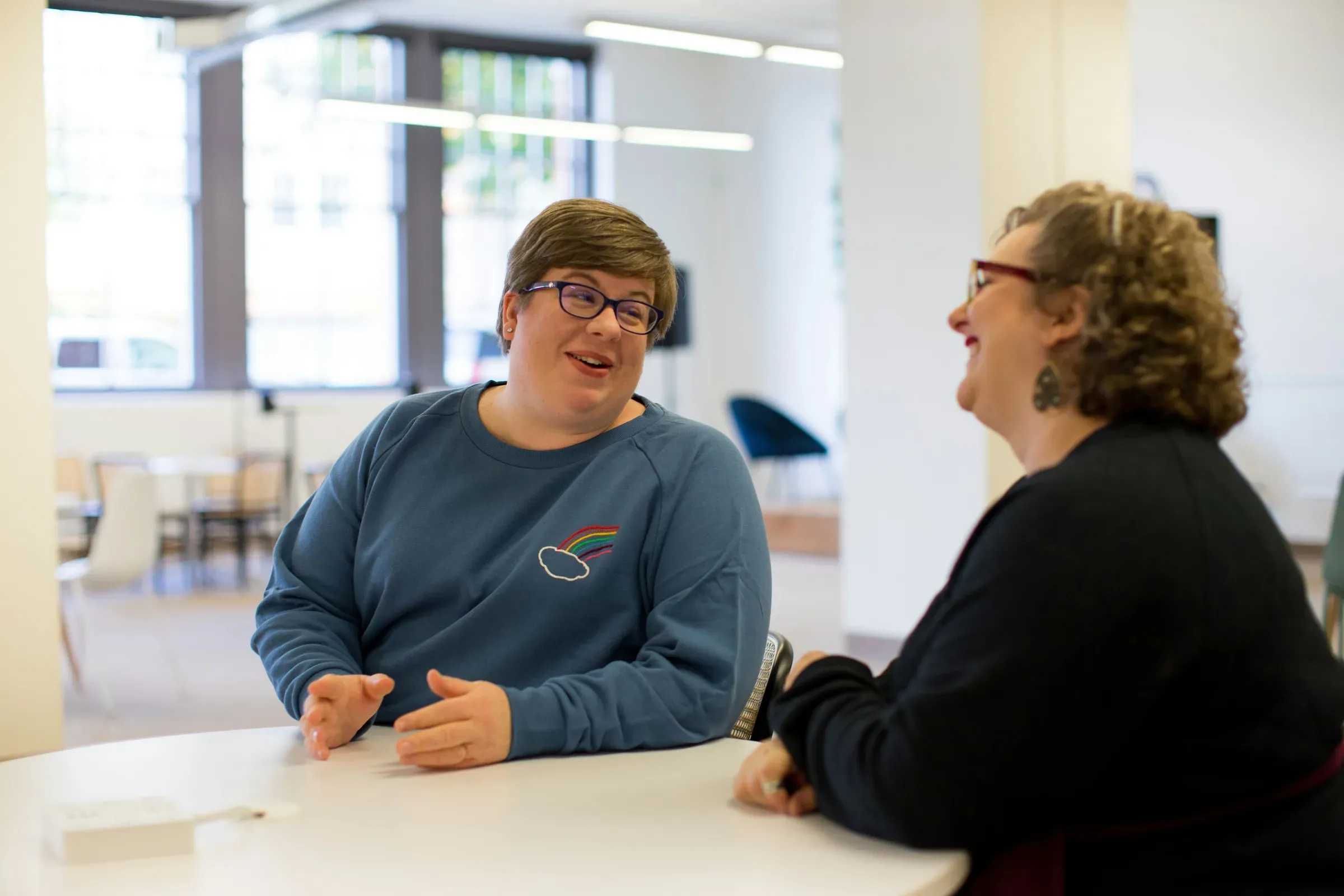 Two adults talking together at a table