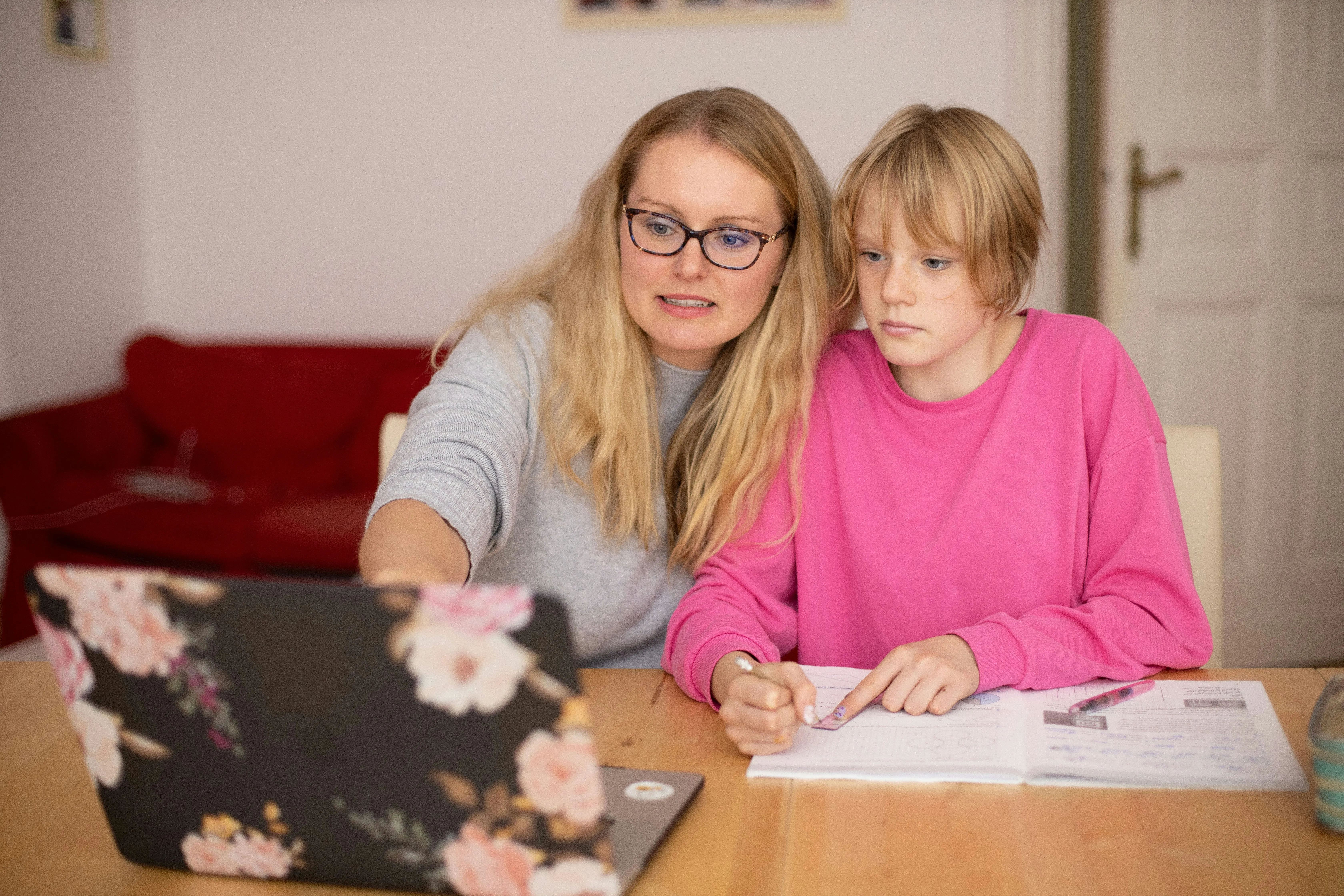 A parent and child working together at a laptop at home