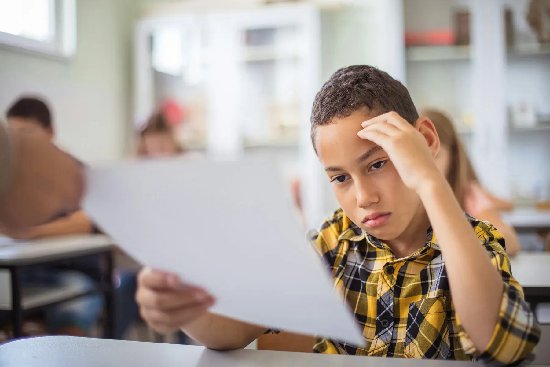 A student looking at a returned paper, hand against their forehead